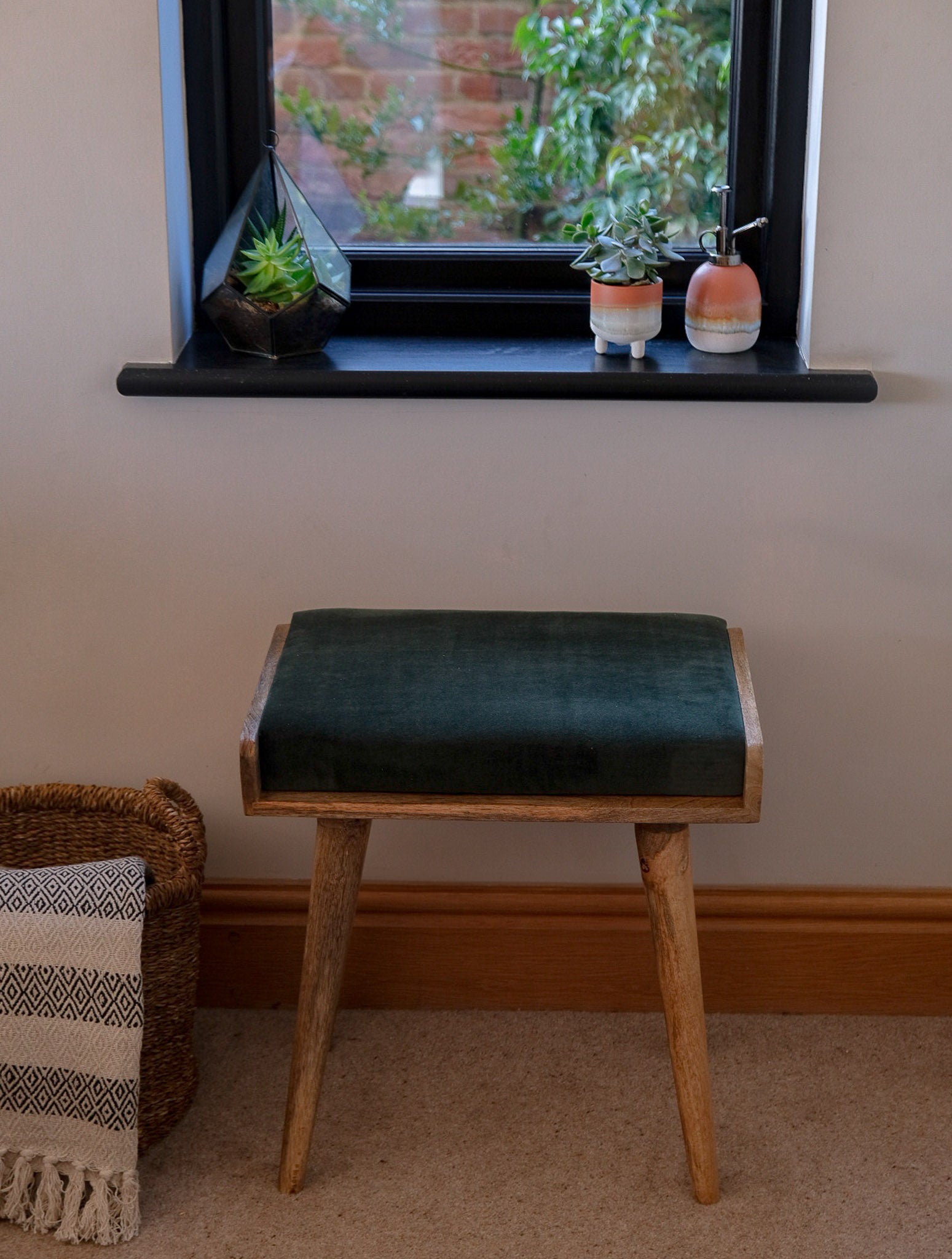 Square solid wood bench with a green velvet upholstered seating pad.