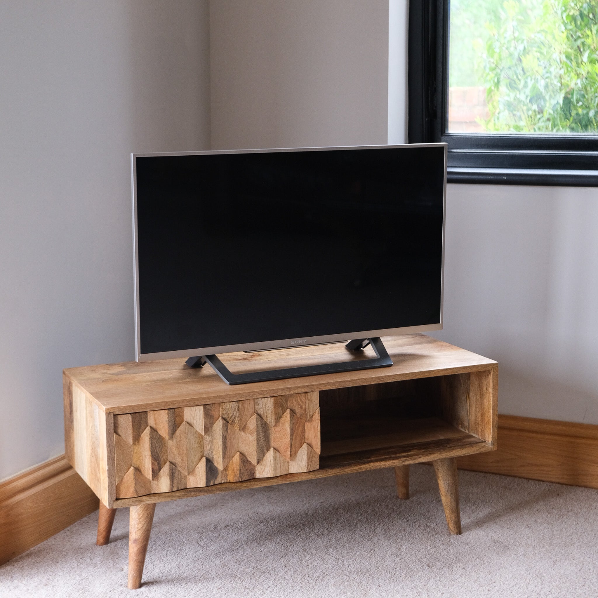 Scandinavian carved TV Stand with solid wood body in a light brown finish.