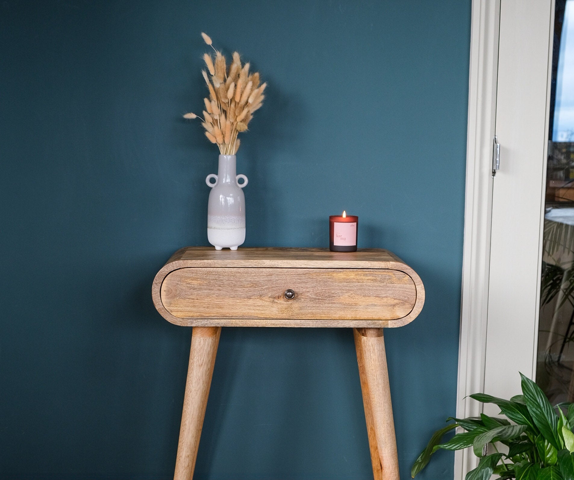 Curved solid wood console table in a natural finish, Scandinavian design. Featuring a single storage drawer, with brass hardware.