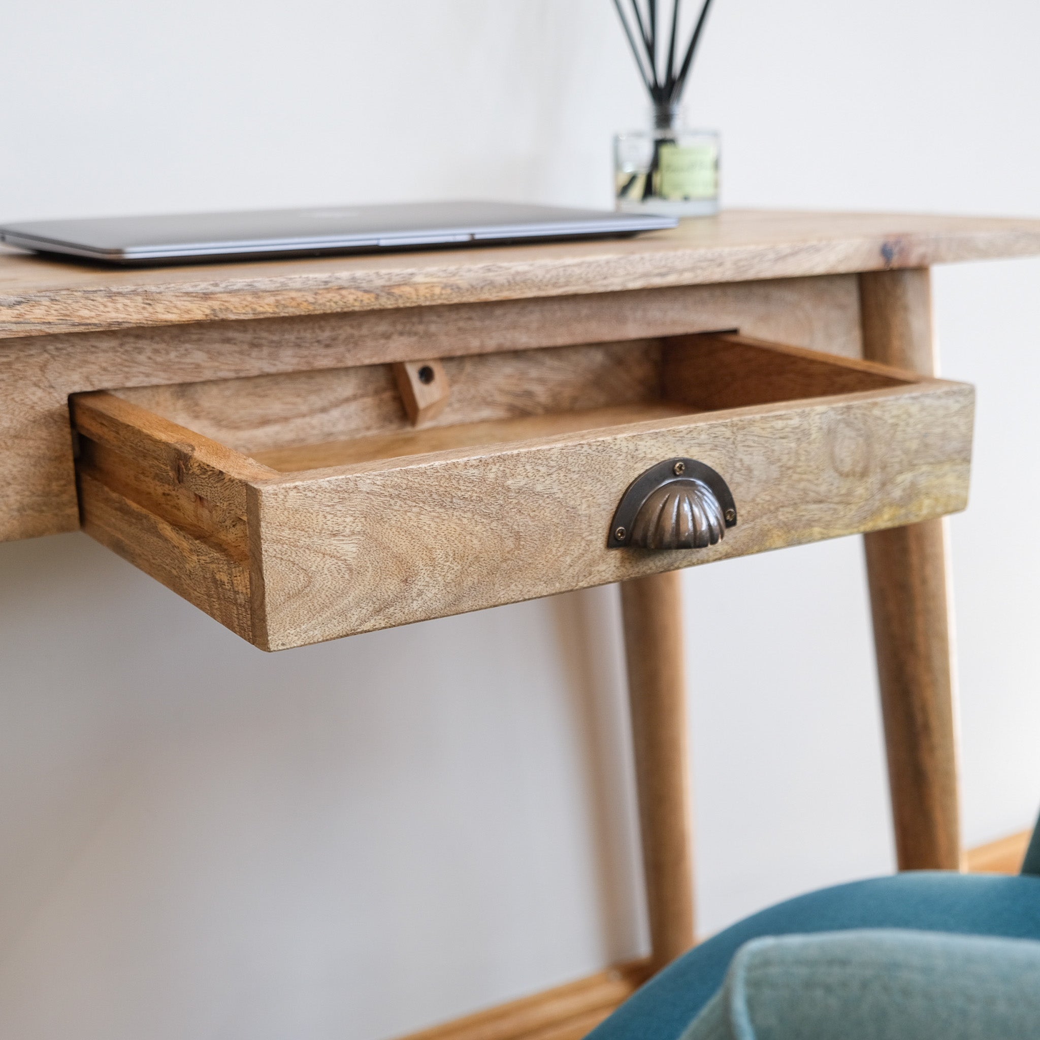 A wooden writing desk with a single drawer open.