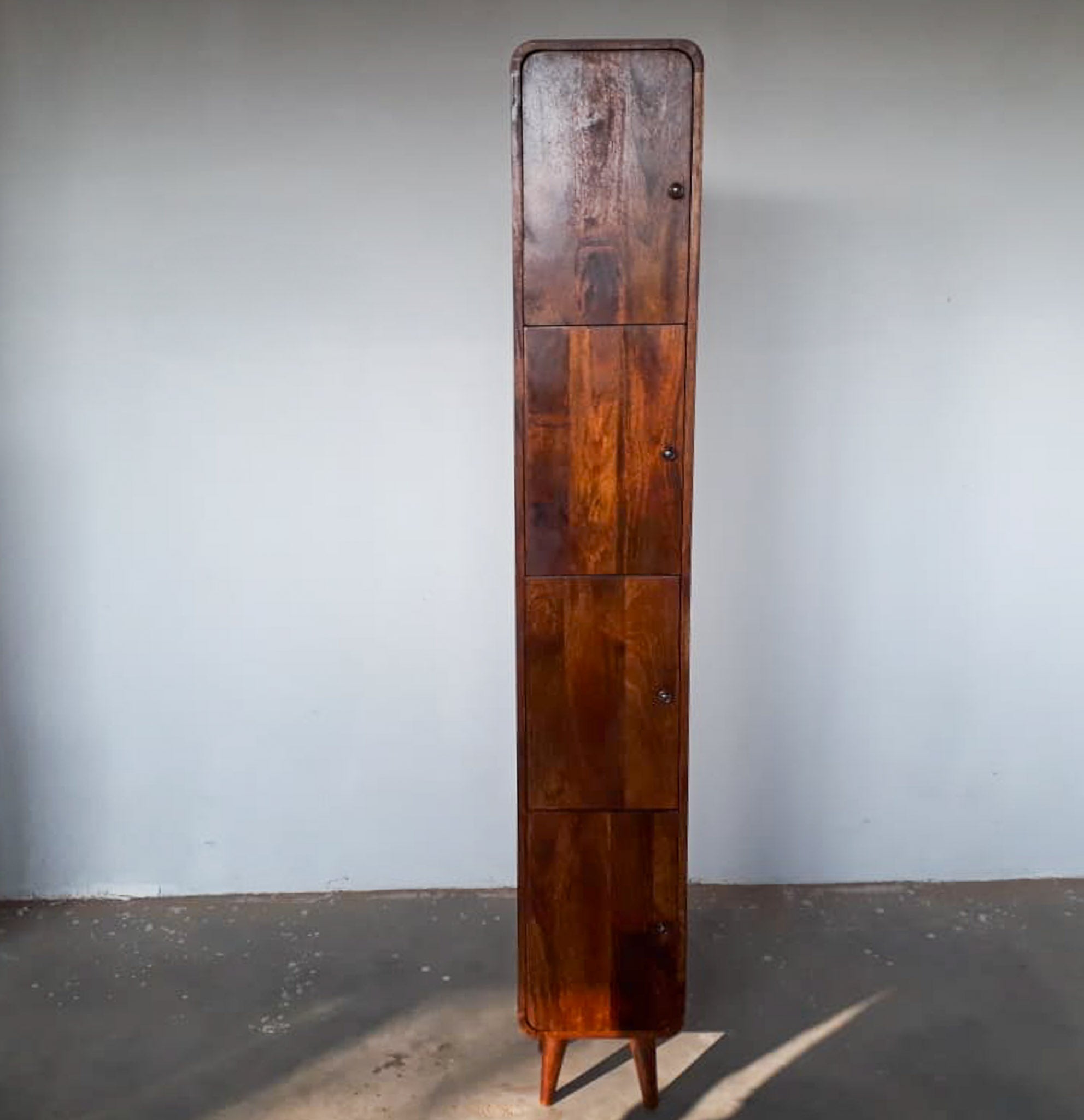 Tall wooden cabinet against a plain wall
