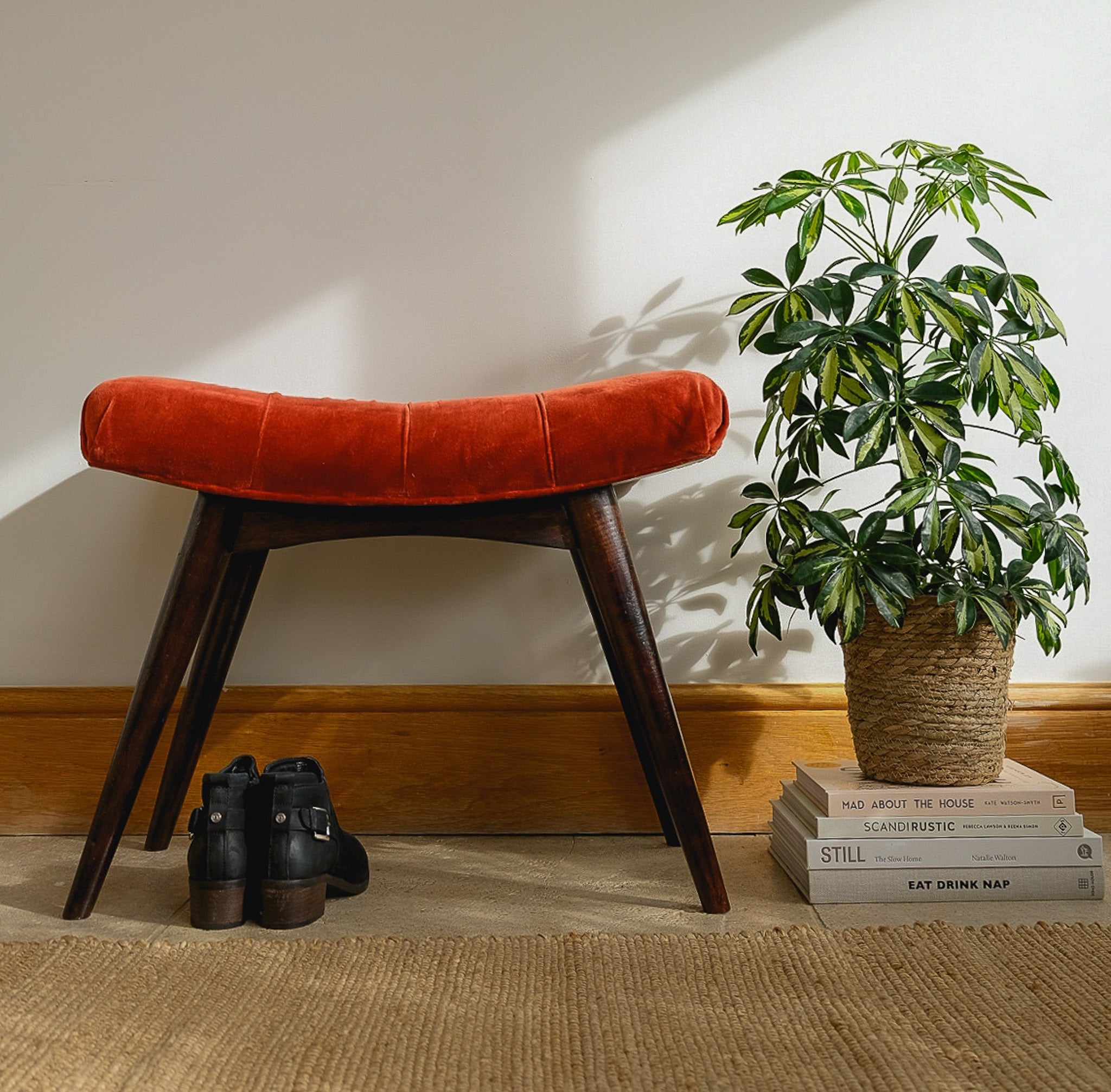 Curved bench upholstered in red fabric, with a dark mango wood body and legs.