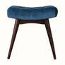 Curved bench upholstered in blue velvet, with dark wood legs.