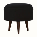 Circular footstool upholstered in black velvet, with dark wood legs.