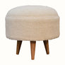 Circular footstool upholstered in cream fabric, Scandinavian style.