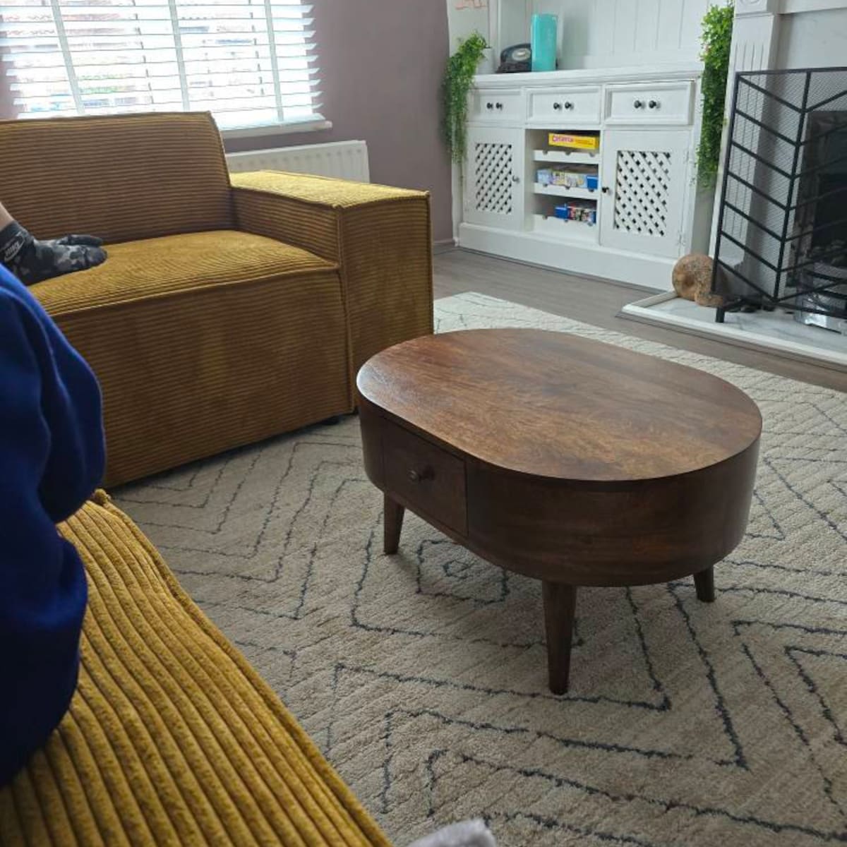 Living room with a wooden coffee table, yellow sofa, and decorative items.