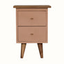 Handpainted bedside table made from solid wood, in a blush pink finish. Bedside features 2 drawers with brass hardware, and four short tapered legs.