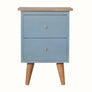 Hand-painted bedside table made from mango wood in a light blue finish. Nightstand features 2 drawers, brass metal hardware, and tapered legs.