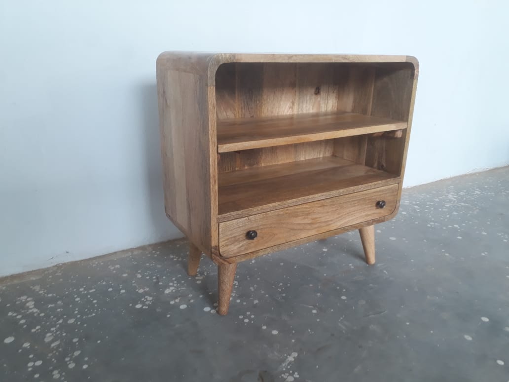 Wooden bookshelf with a drawer on a gray floor against a light blue wall
