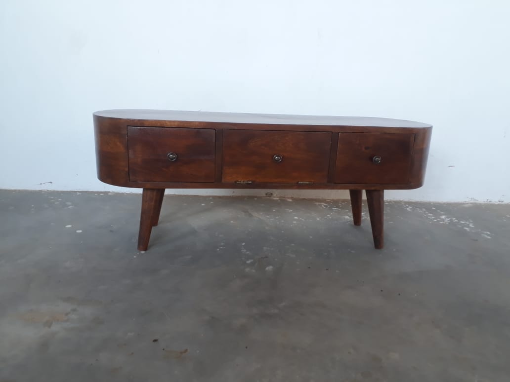 Wooden tv stand  table with three drawers on a concrete floor.