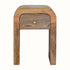 Small curved bedside table made from mango wood in a light brown finish.