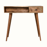 Desk crafted from solid mango wood in a light brown natural finish, with brass shell handle, one storage drawer and an open slot shelf. 