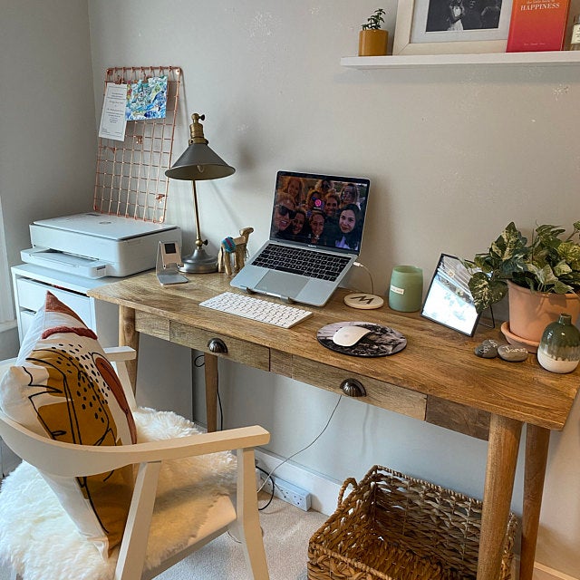 A stylish home office with a solid wood desk in a light brown finish.