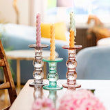 Three glass candle holders in grey, blue amd pink. 