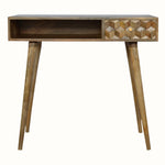 A natural finish mango wood writing desk with a textured cube-carved design, featuring a single drawer, four Nordic-style legs, and brass knob detailing.