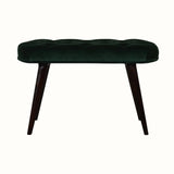 A emerald green velvet bench with walnut wooden legs, featuring deep button detailing.