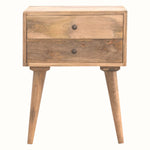 A natural finish mango wood bedside table with two drawers and brass knobs, featuring tapered legs.