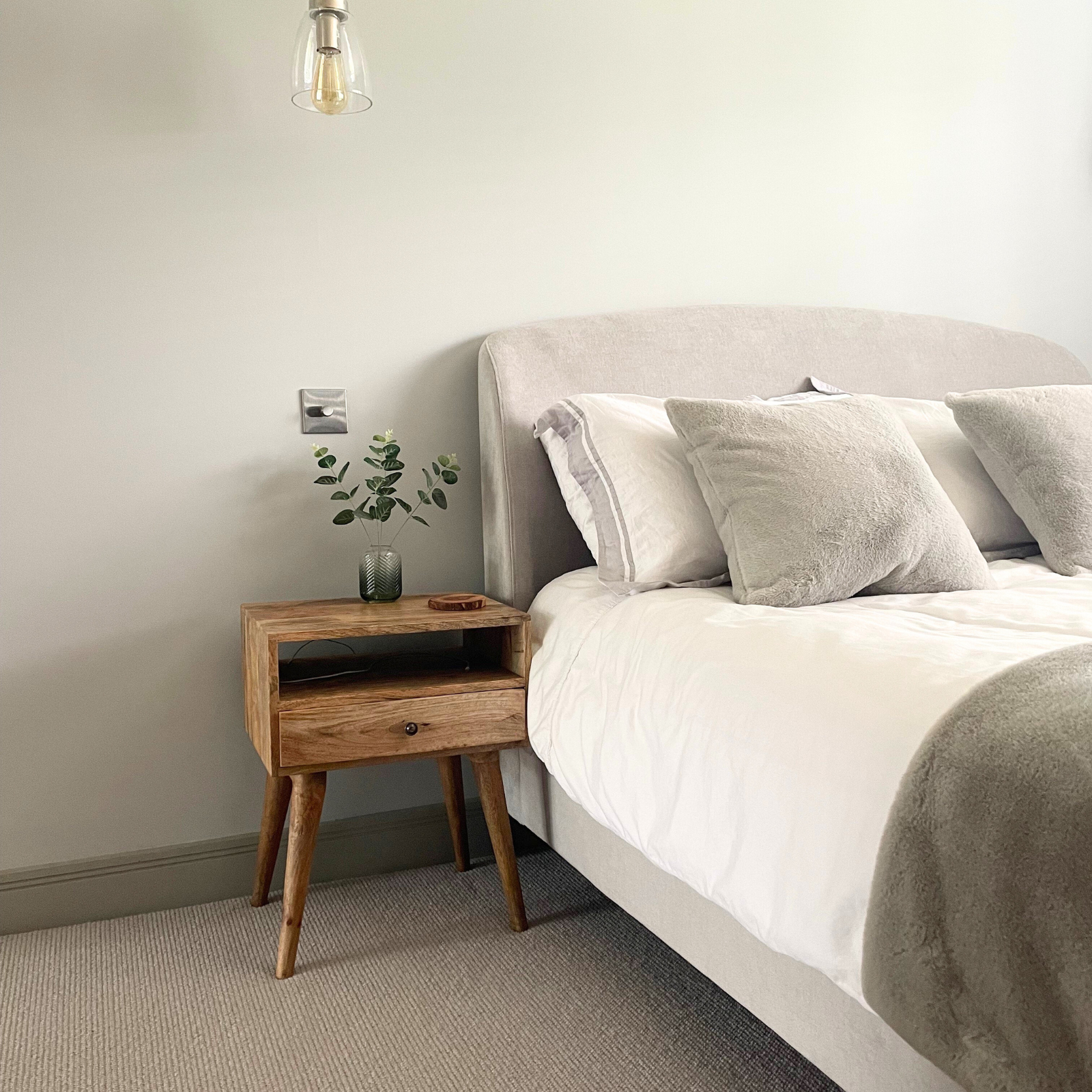 Neatly made bed with gray bedding in a bedroom setting.