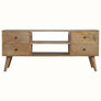 A natural wood TV stand with four drawers and two open slot shelves, featuring brass knobs and short tapered legs.