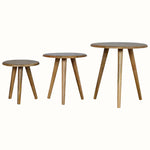 A set of three natural finish mango wood stool chairs with tapered legs, in varying sizes, against a white background.