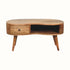 A medium-sized, natural finish wood coffee table with a single drawer and open shelf, featuring tapered legs and brass knob detailing.