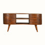 A vintage-style media unit with a chestnut finish, featuring a curved silhouette, brass knobs, and four drawers with open slot shelves on top.