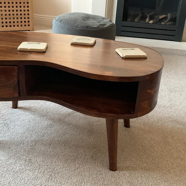 Wooden coffee table with a wavy design in a living room setting.