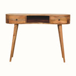 A large, natural finish mango wood writing desk with an open slot shelf and two drawers, featuring a brass knob and four tapered legs.
