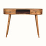 A large, natural finish mango wood writing desk with an open slot shelf and two drawers, featuring a brass knob and four tapered legs.