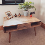 Living room featuring a light brown wooden coffee table, with decorative objects on top. 