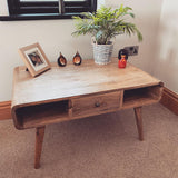 Living room featuring a light brown wooden coffee table, with decorative objects on top. 