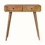 Light brown mango wood console table with curved edges, two drawers, brass knobs, and tapered legs.