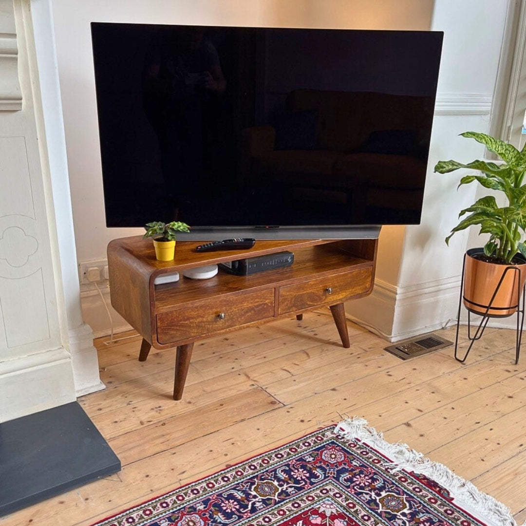 Dark brown mango wood TV stand with a large flat-screen TV in a living room setting.
