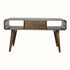 A grey wash Hamade open coffee table made of solid mango wood, featuring two open slot shelves, two drawers, and four tapered legs with brass knob hardware.