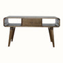 A grey wash Hamade open coffee table made of solid mango wood, featuring two open slot shelves, two drawers, and four tapered legs with brass knob hardware.