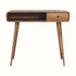 A natural wood writing desk with four legs, featuring a drawer and an open shelf.