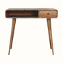 A natural wood writing desk with four legs, featuring a drawer and an open shelf.