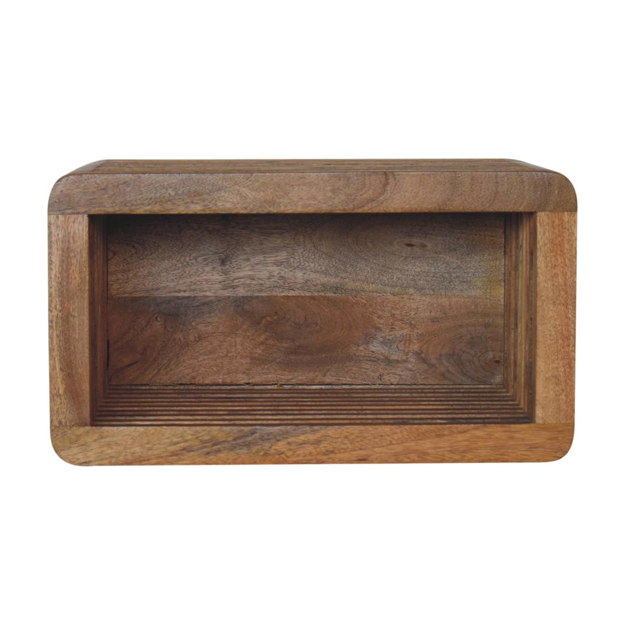 A chunky open rectangle wall-mounted bedside table made from mango wood in a natural finish.