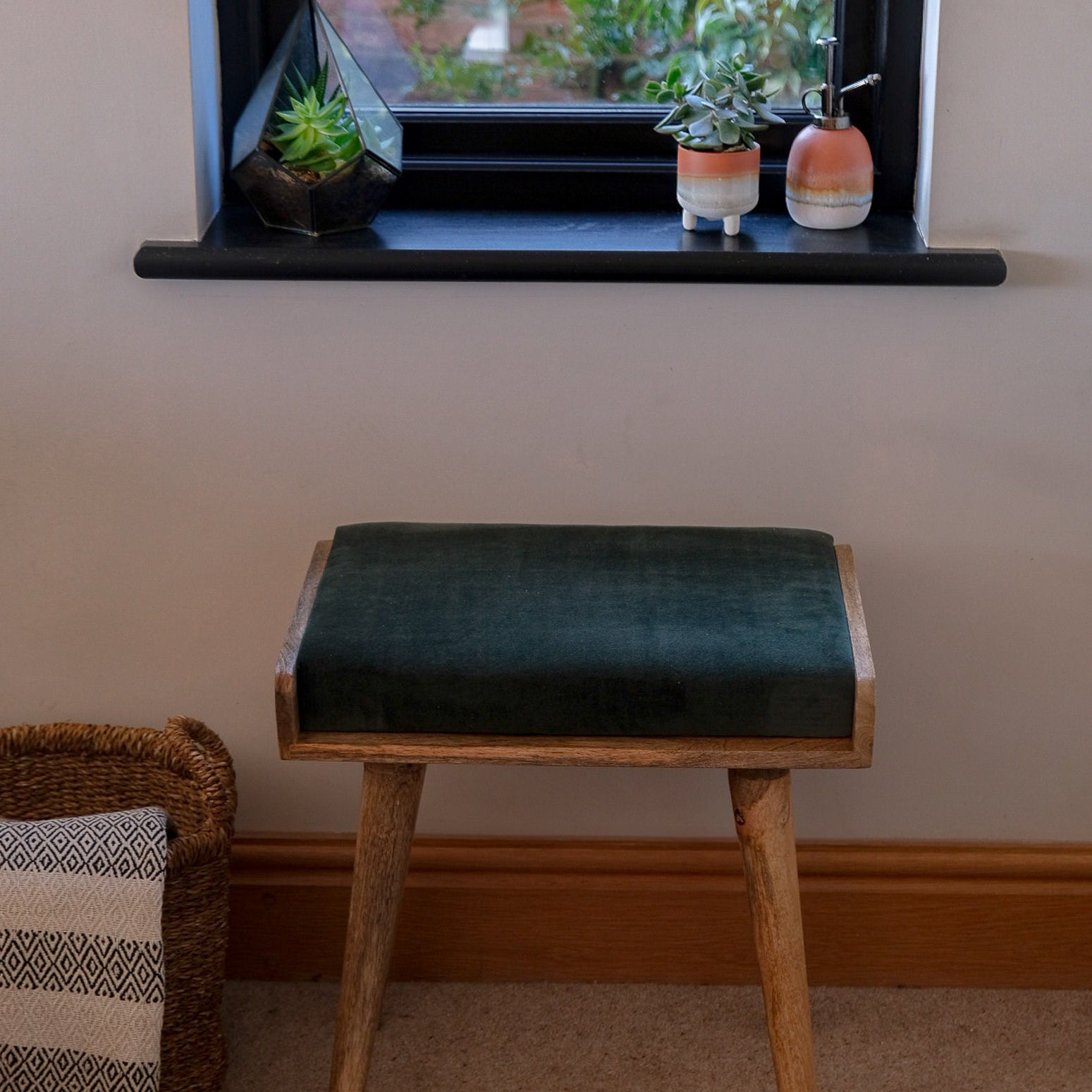 Square solid wood bench with a green velvet upholstered seating pad.