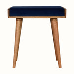 Small square tray-style bench in a dark blue velvet, and a natural wooden body.