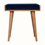 Small square tray-style bench in a dark blue velvet, and a natural wooden body.