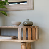 Corner of a wooden slatted console stylishly decorated.