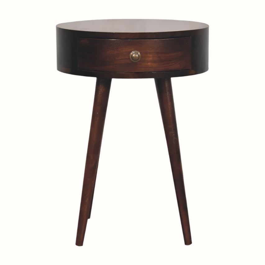 A brown Lauro bedside table made of California walnut, featuring a round tabletop with a single drawer and brass knob.