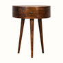 A semi circular shape bedside table made from mango wood in a dark brown finish, featuring a small drawer and single brass knob.