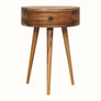A semi-circular bedside table with a natural wood finish, featuring a single drawer and three legs.