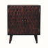 A small light walnut Marina cabinet with two carved doors featuring a pineapple pattern and brass knobs, perched on four short Nordic-style legs.