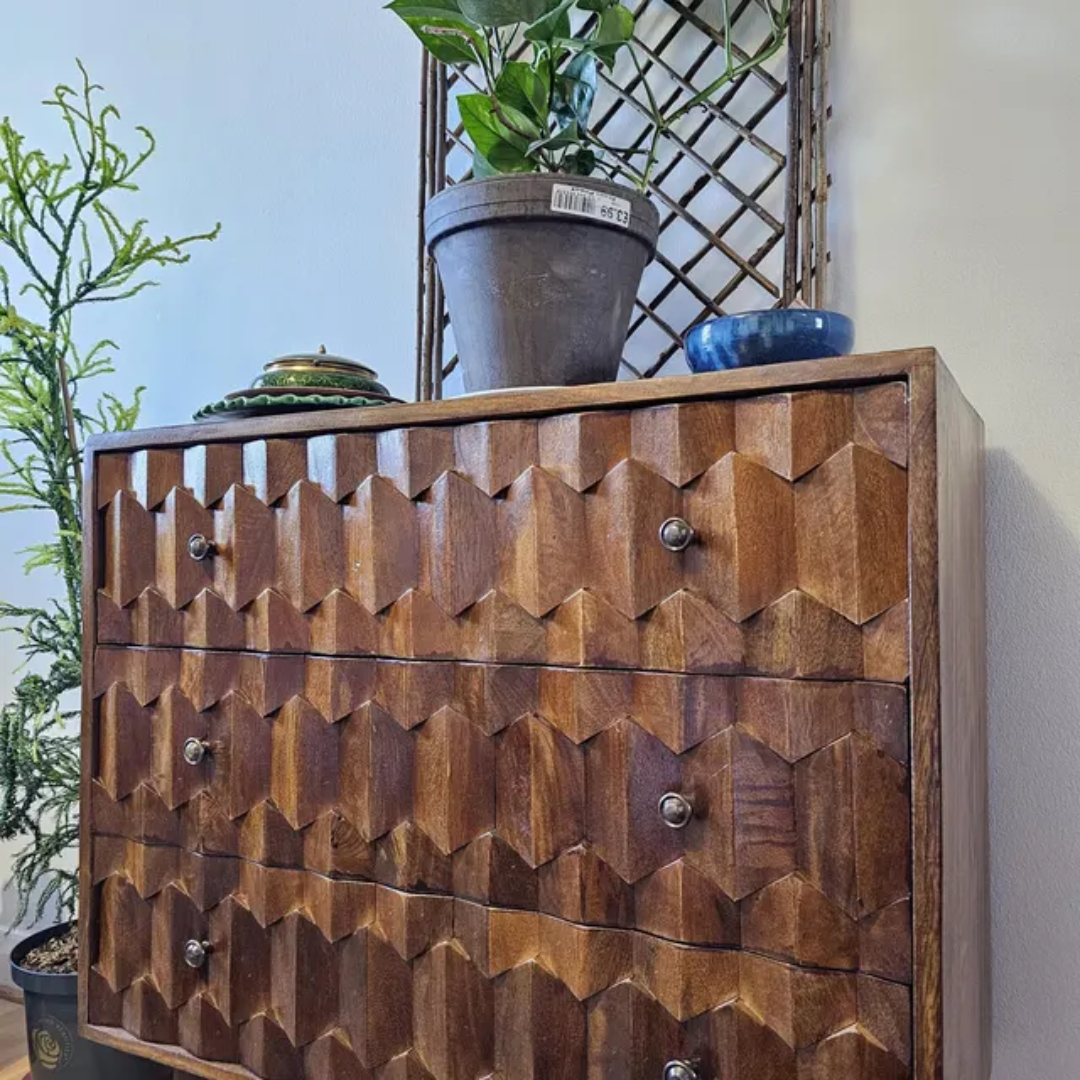 Chest of drawers in a dark wood stain, with 3 drawers and a pineapple carved design.