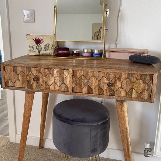 Mango wood vanity table with mirror, stool, and small items in a room setting.
