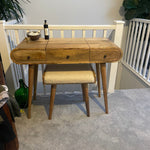 Curved dressing table in a light brown stain, with a square boucle bench.