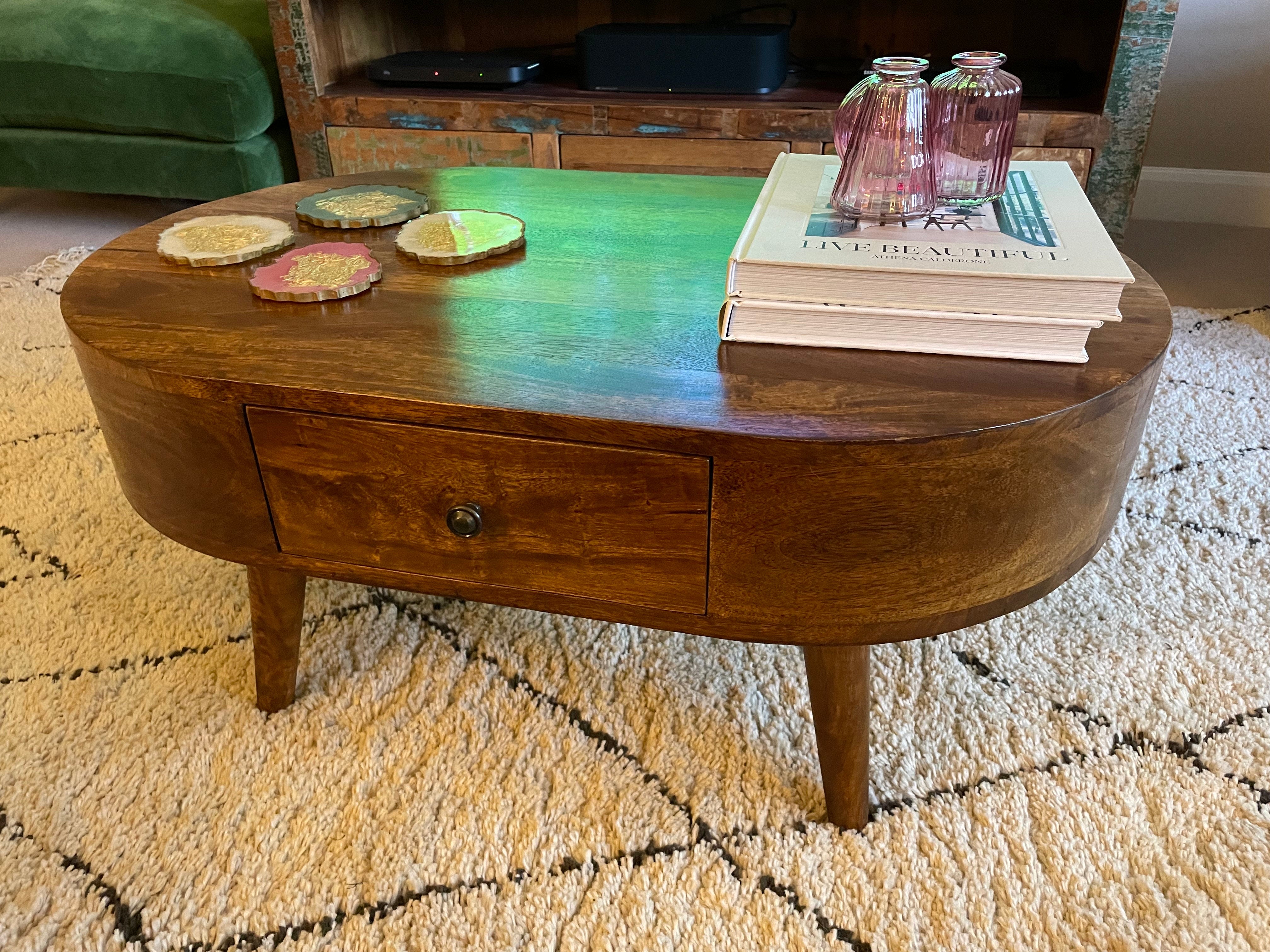 Wooden coffee table with books and decorative items on a patterned rug